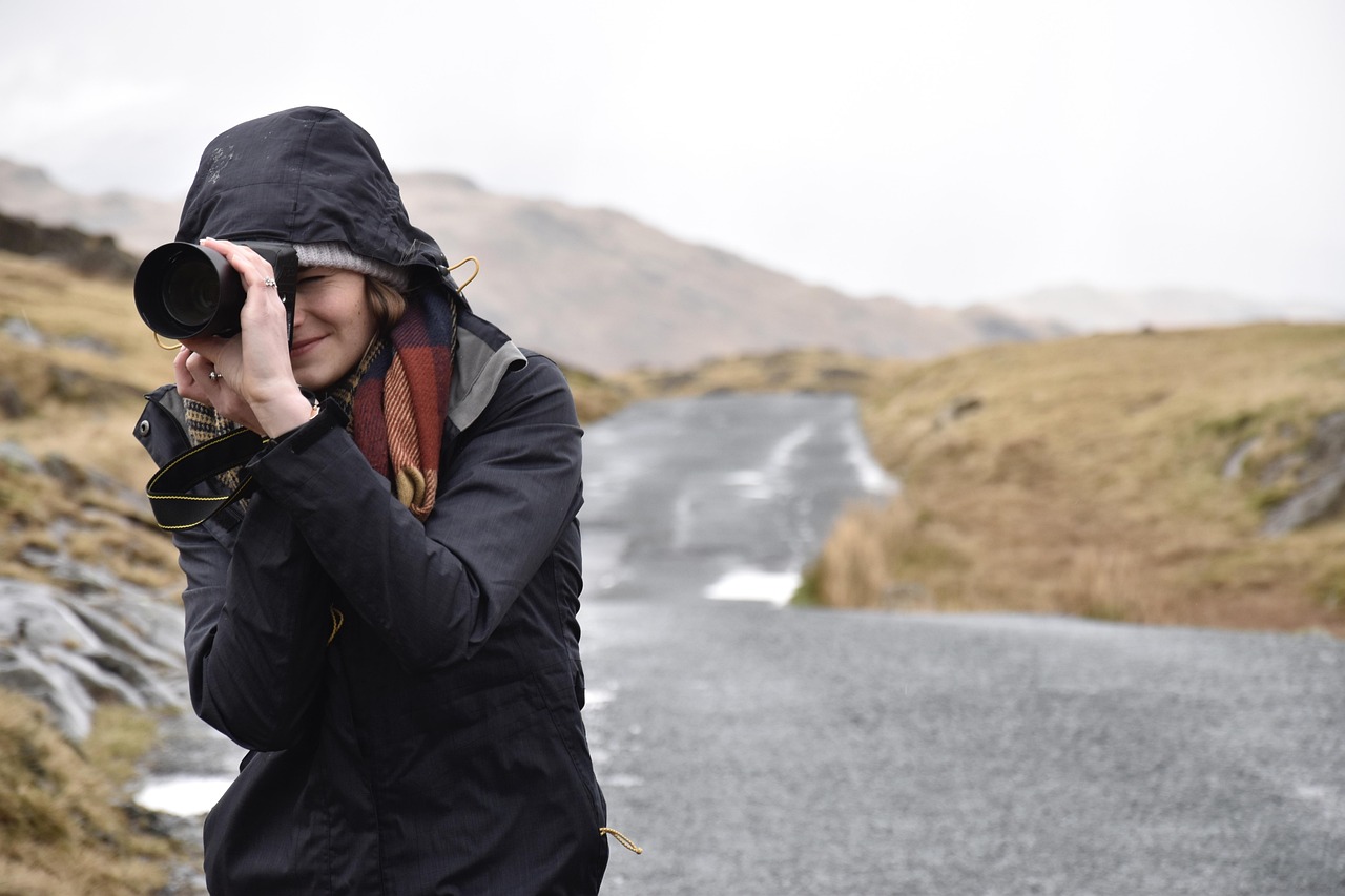 woman outside photographing with a camera