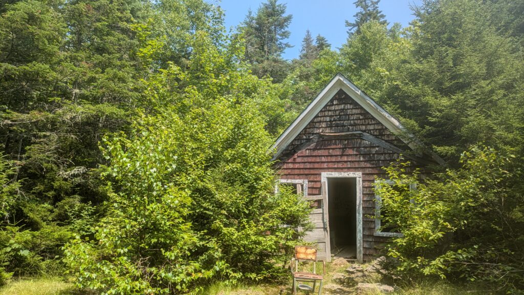 rusted chair outside an old shack in the woods on Mount Chase in Maine
