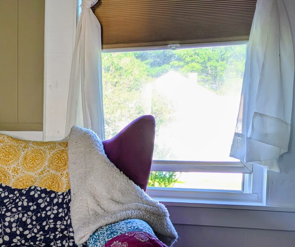 plum colored chair by a window